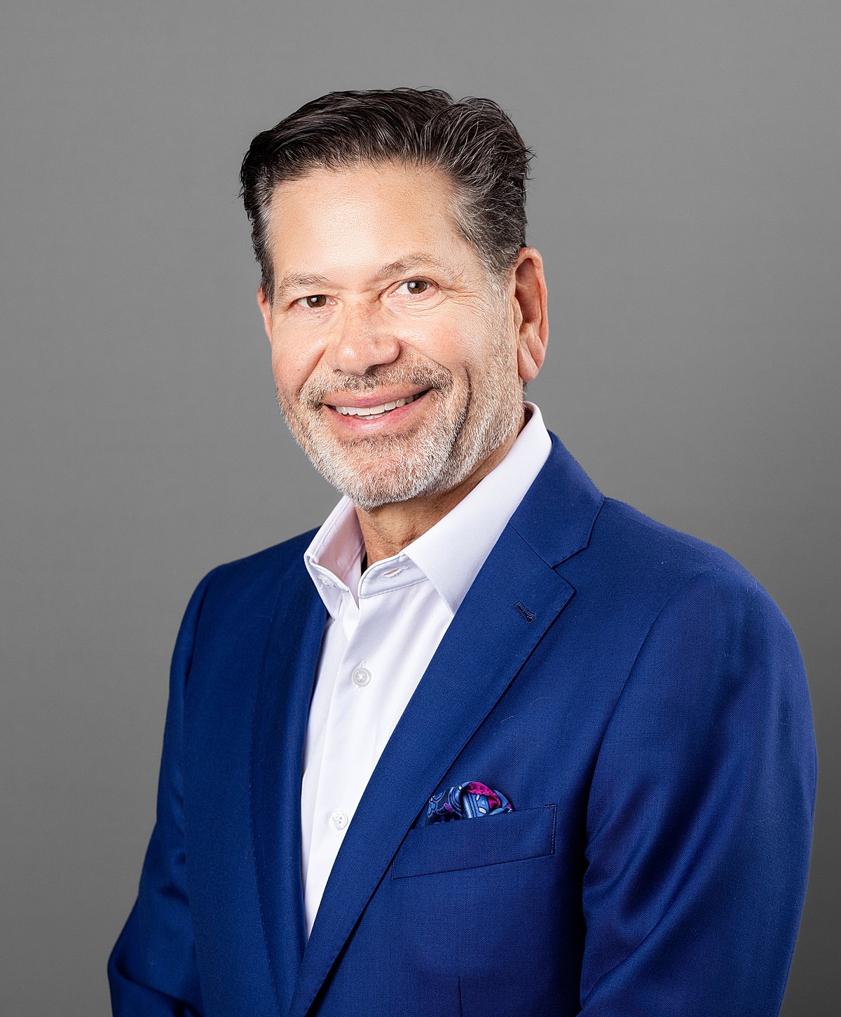 Smiling man in a blue suit with pocket square.