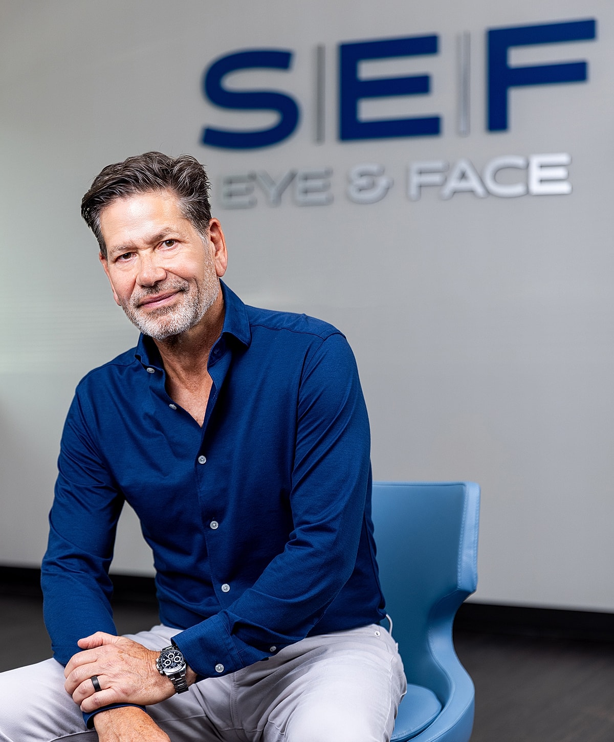 Man seated in office, smiling. SEF logo visible.