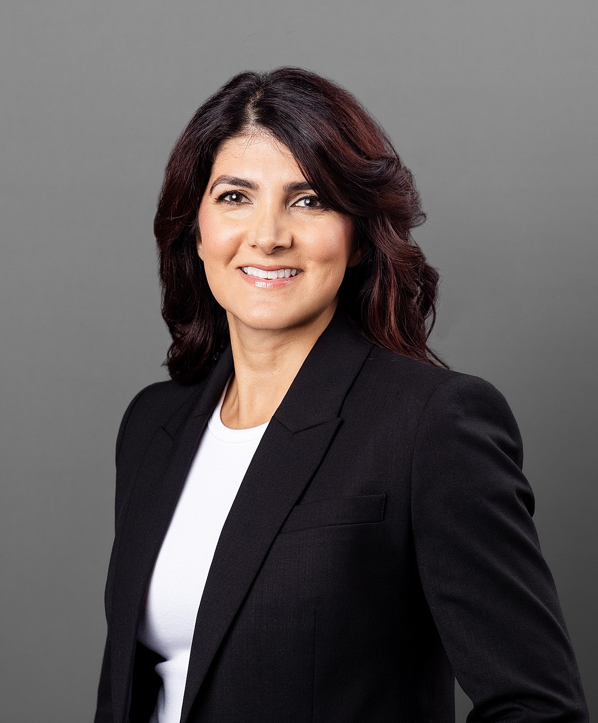 Professional woman in a black blazer smiling.