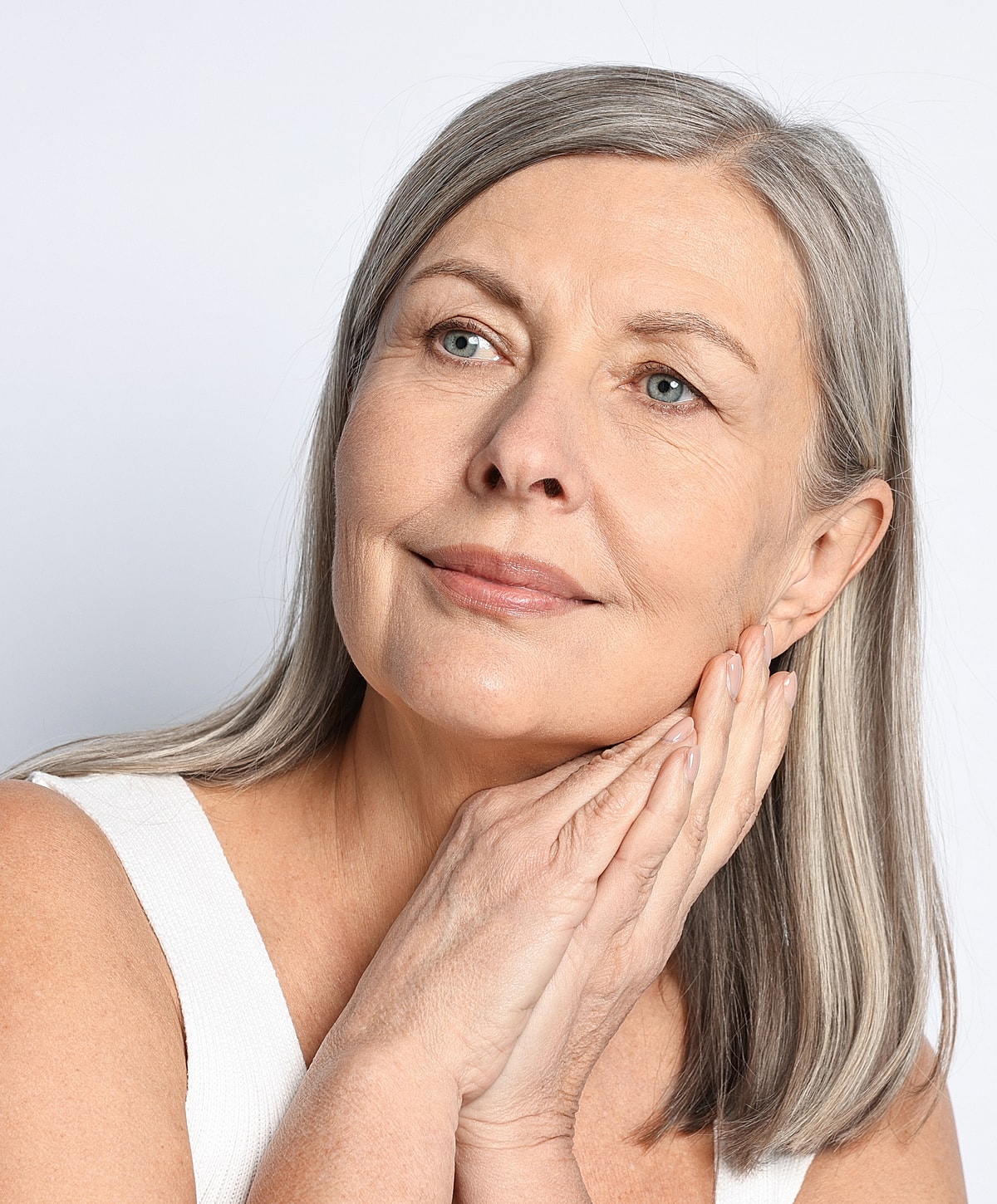 Smiling older woman with gray hair, thoughtful expression.