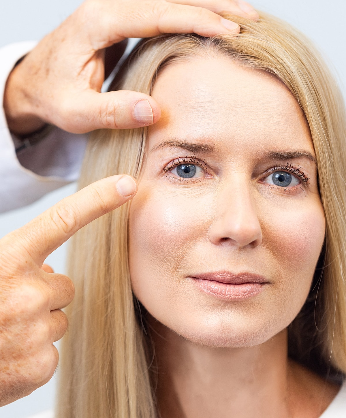 Consultation for cosmetic procedure on woman's face.