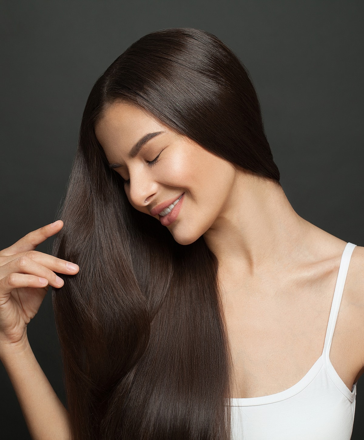 Woman with long, smooth, dark hair smiling.