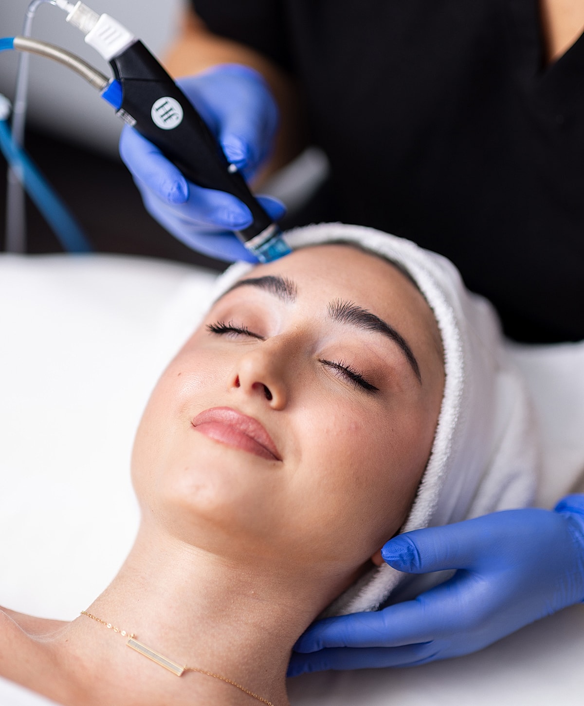 Facial treatment with device on relaxing client.
