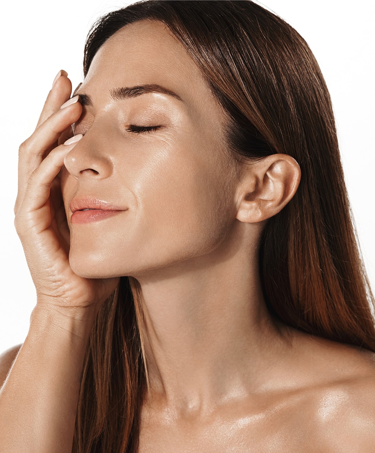 Woman with closed eyes, softly touching her face.
