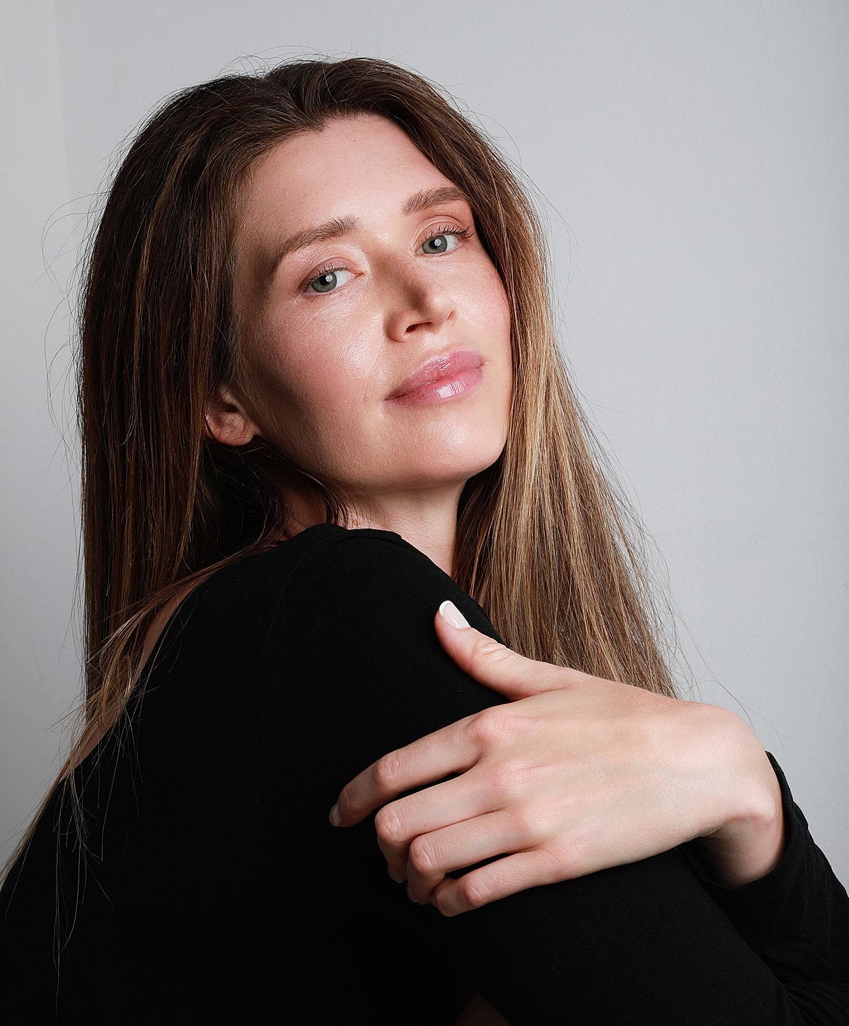 Woman with long hair, smiling gently.