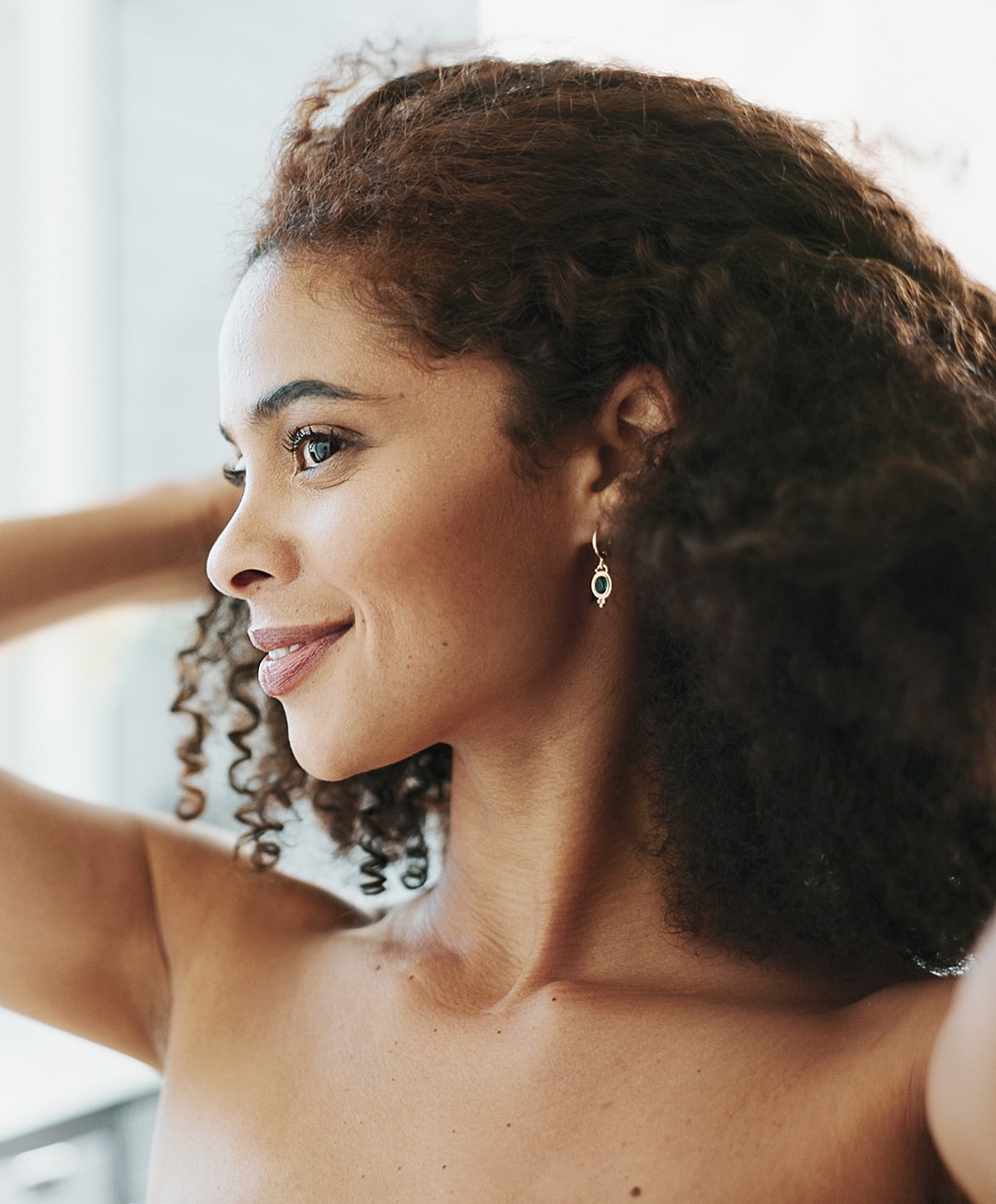 Woman with curly hair and earrings.