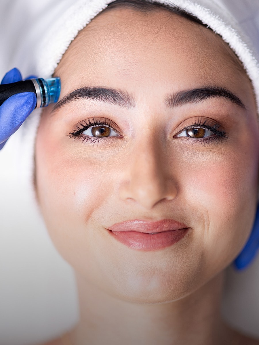Woman receiving facial treatment with a device.