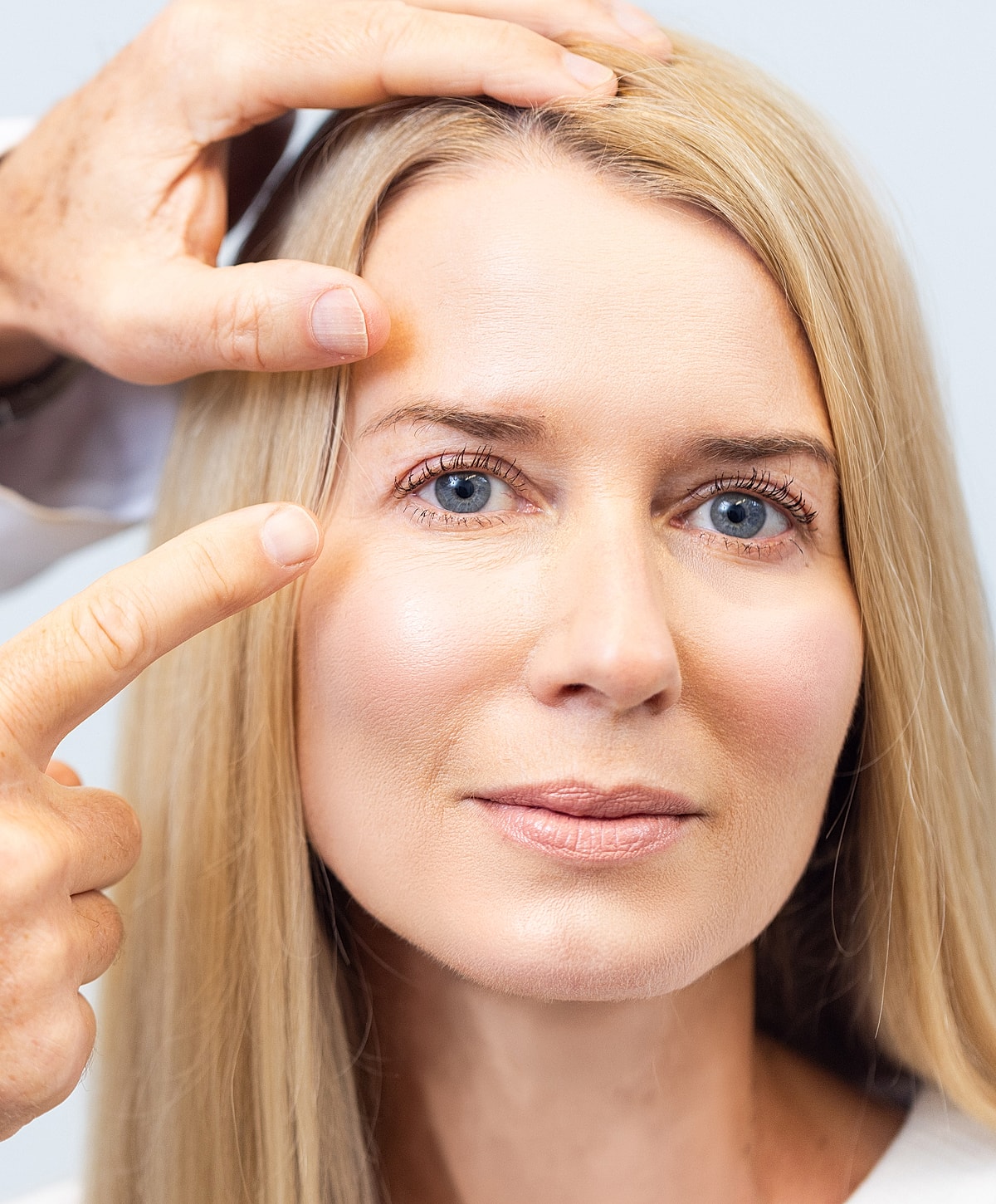 Woman receiving cosmetic treatment around eyes.