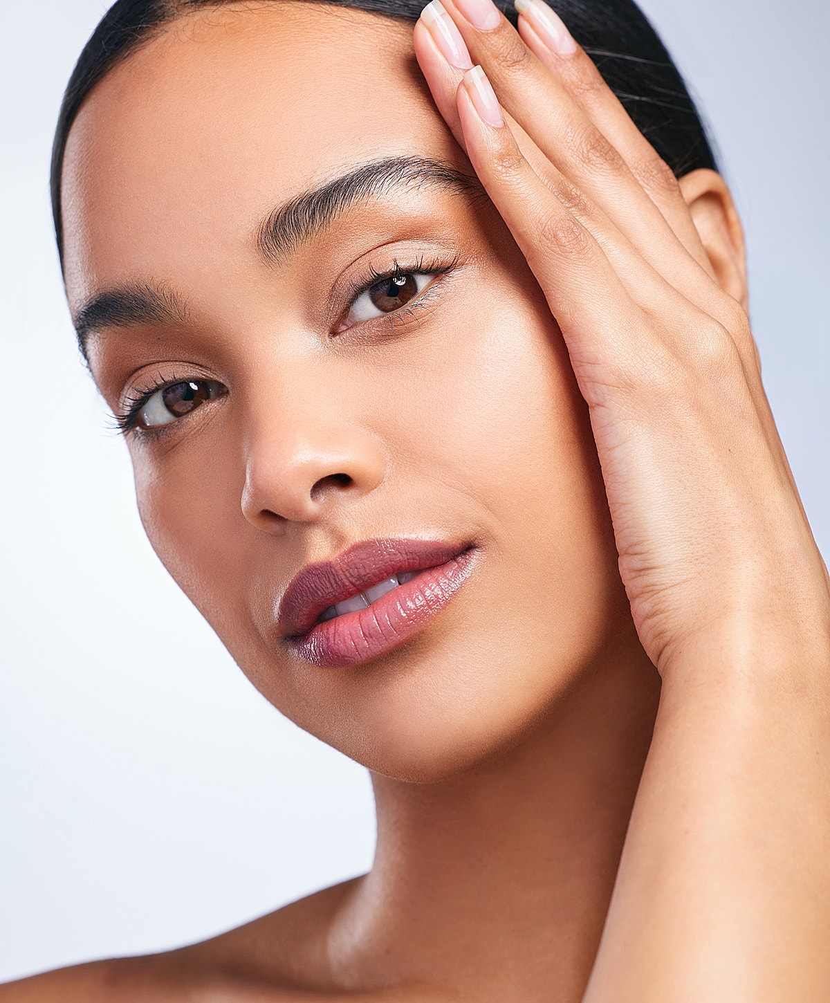 Close-up of a woman with glowing skin.