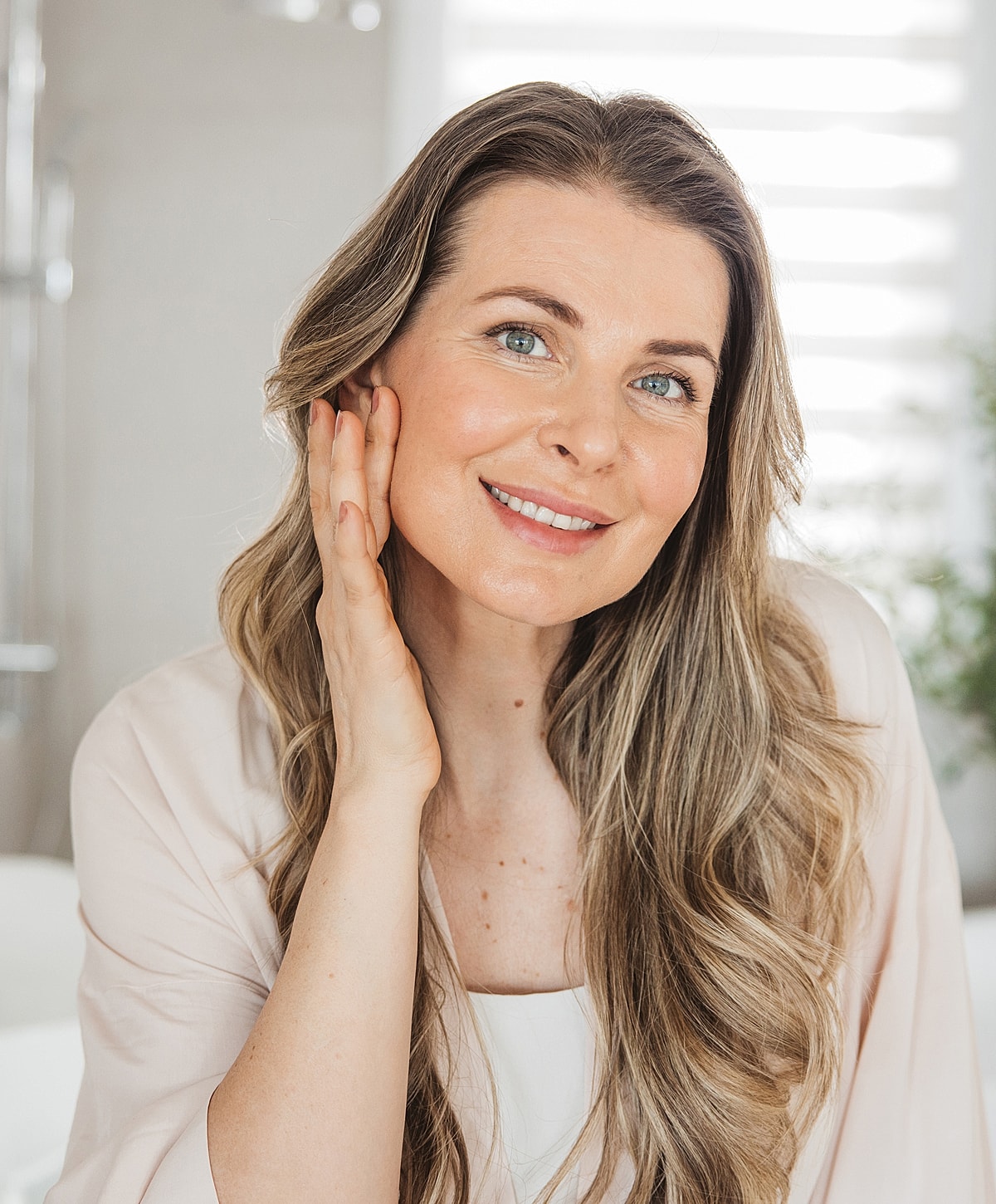 Woman smiling and touching her face gently