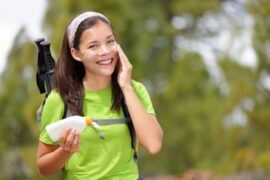 Woman rubbing sunscreen on her face