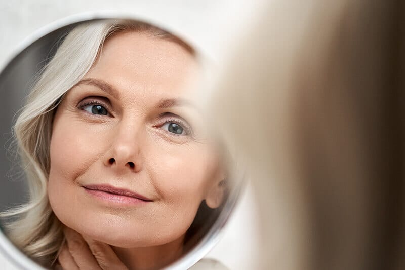 Mature woman looking in mirror
