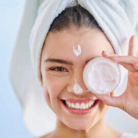 Woman with facial cream container over her eye