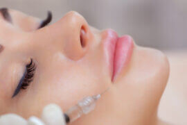 The doctor cosmetologist makes Lip augmentation procedure of a beautiful woman in a beauty salon
