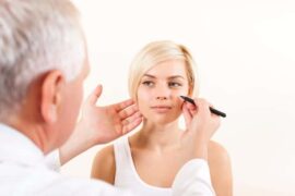 Doctor marking woman's face for cosmetic procedure